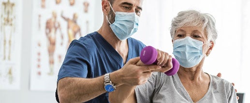 A provider helps rehabilitate an elderly woman's shoulder with a weight routine