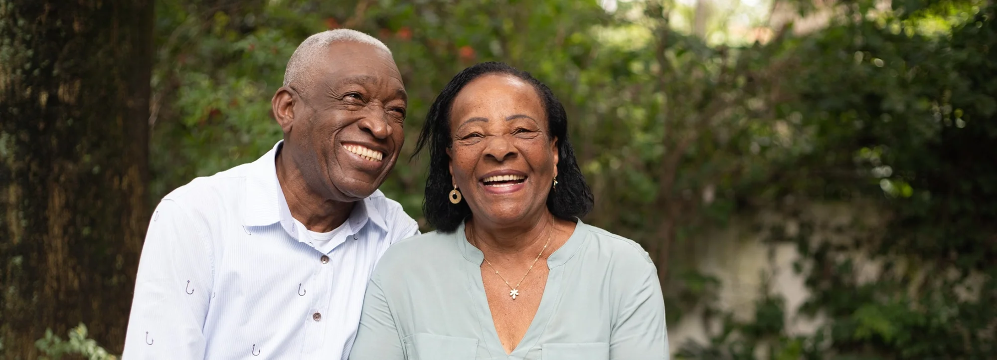 A senior couple smile together outside