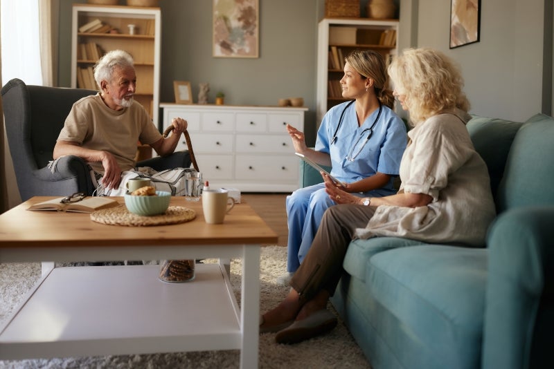 Older man and woman sitting and speaking with a provider
