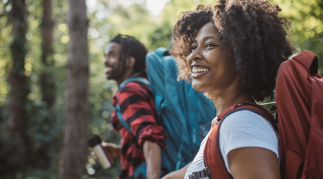 Young couple backpacking in the back woods on a sunny day.