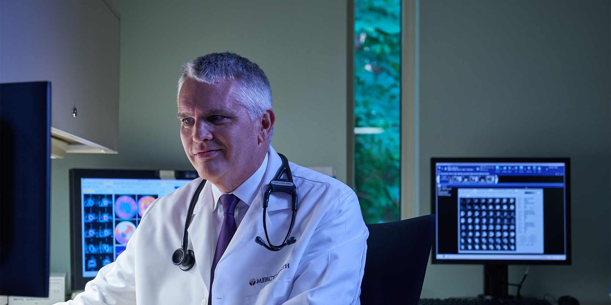 A physician does rounding with a group of other providers at the hospital