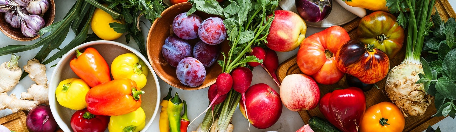 An assortment of vegetables spread across a table, including peppers, ginger, radishes and more.