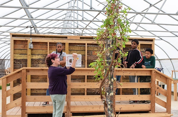 An employee of The Farm teaches school children about agriculture