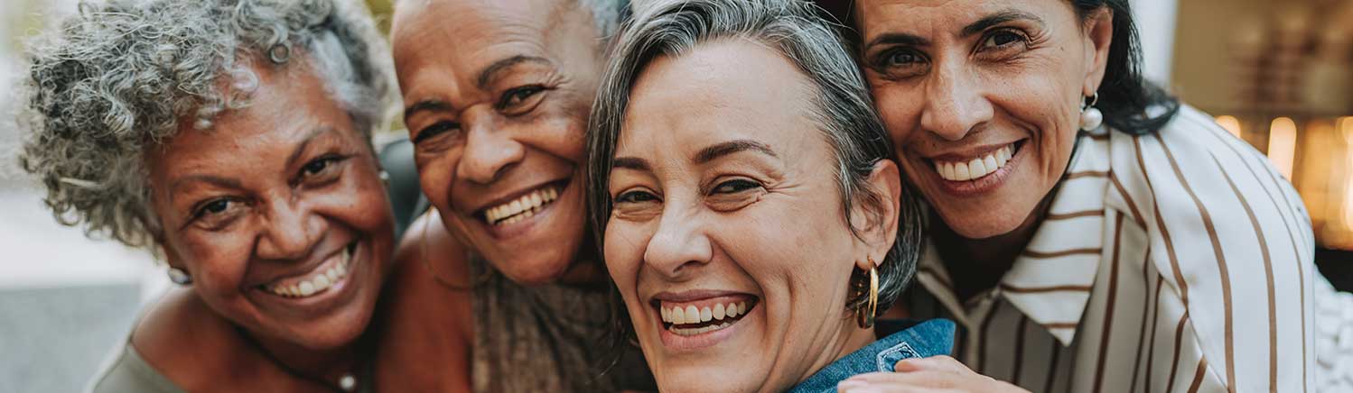 Four women group together for a photo. They look really happy.